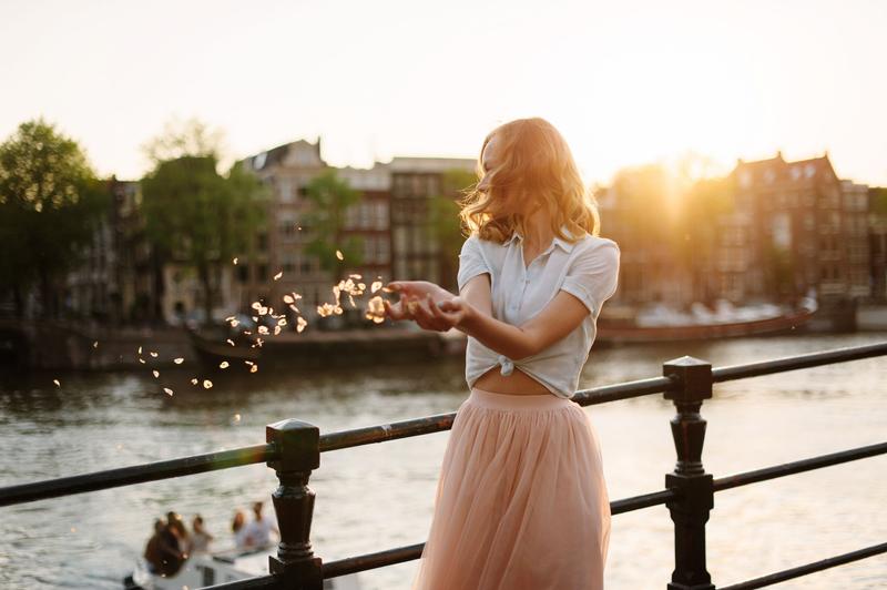 High-class escort companion in Amsterdam by the canal at sunset